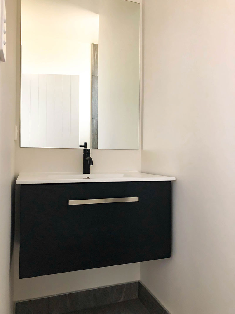 Black Elementi tapware and black vanity with white top, grey tiled floor