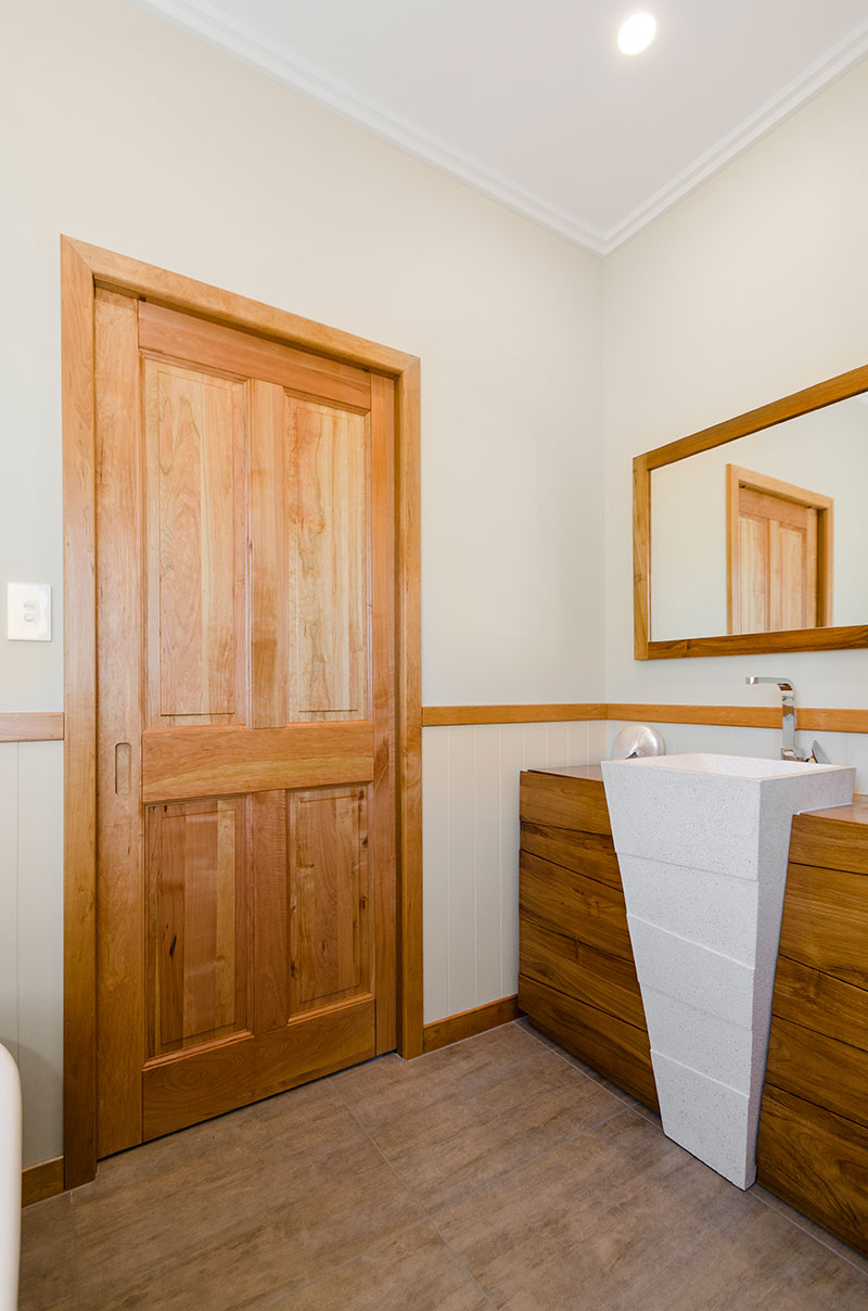 Unique wood and stone vanity in bathroom with timber accents of Award winning colonial home in Waiau Pa