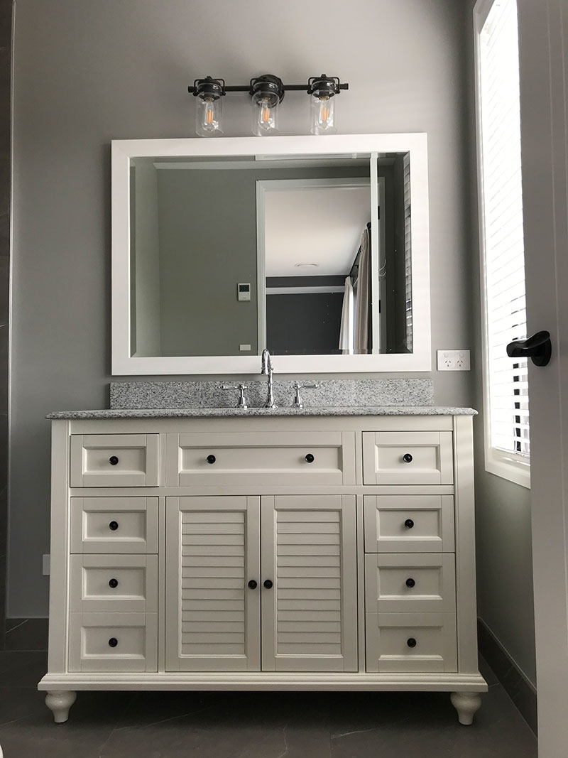 Traditional / Colonial style vanity with stone top, traditional tapware and feature light