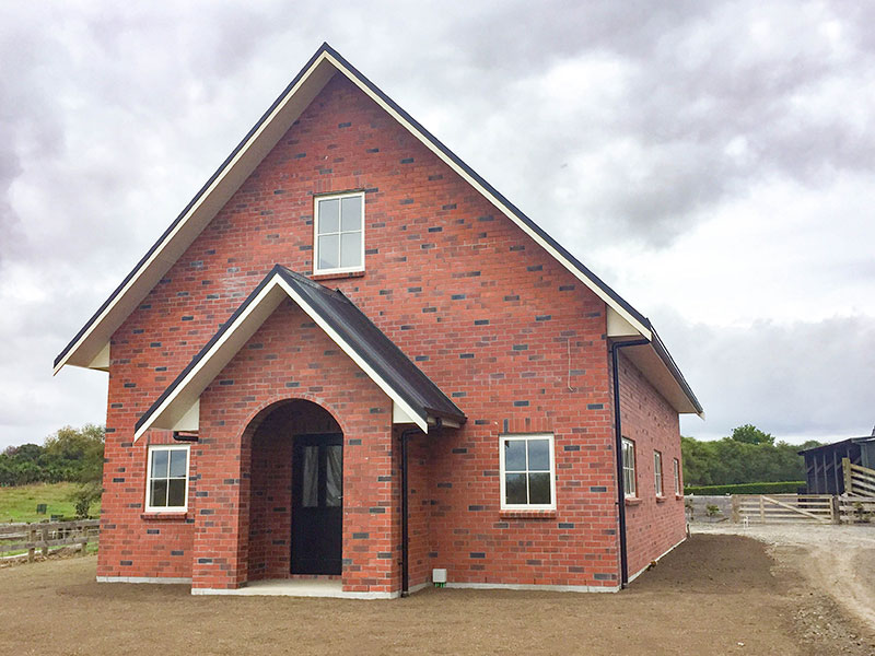 Victorian style barn/shed with living quarters. Red brick. Church look