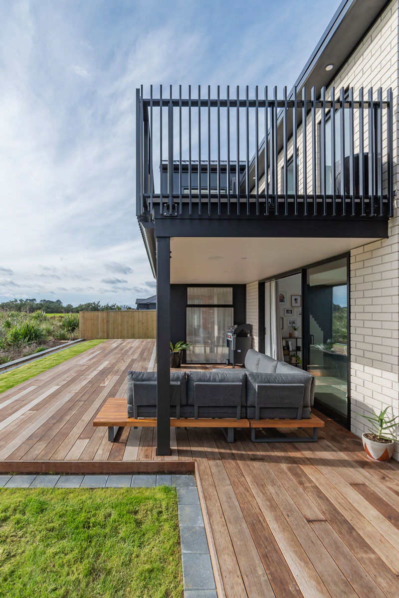 Beauitful back deck of designer home in Glenbrook. White brick with black trim and balcony deck