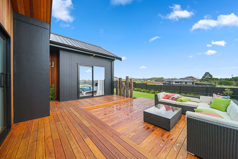 Paerata Rise Showhome back deck with outdoor couch and peach and green cushions