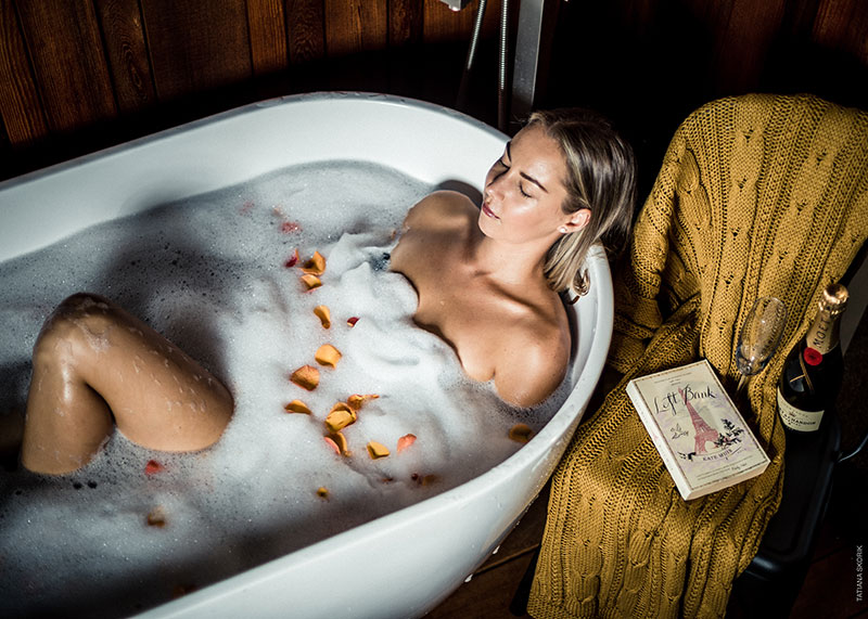 enjoying a beautiful outdoor bath with bubbles and rose petals. Tub on deck in sheltered area