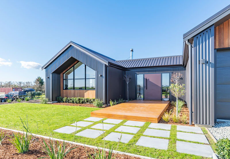 Beautiful welcoming entrance with timber decking and concrete pavers on award winning pavillion style home