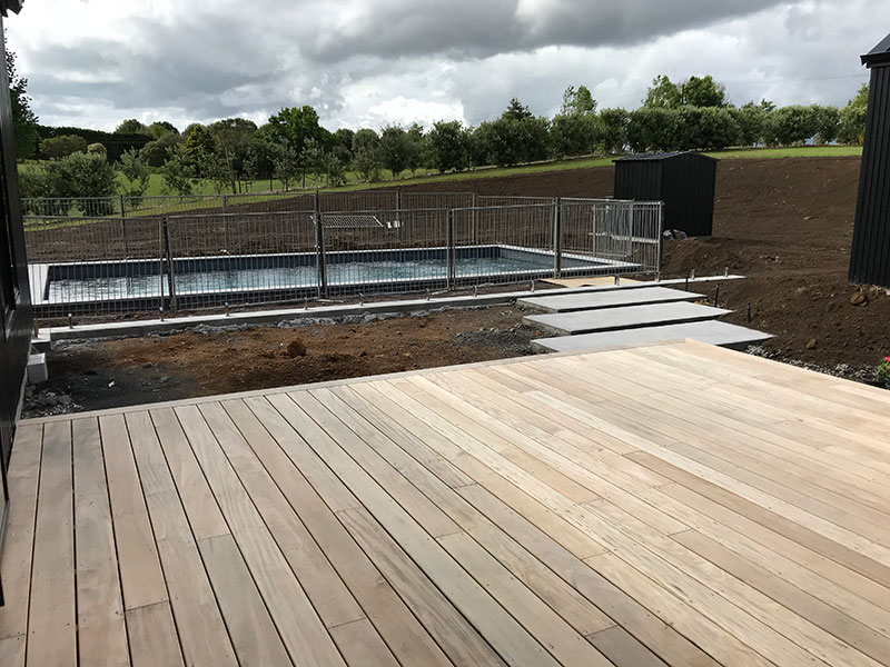 pool area on modern barn style home with concrete slab path from deck