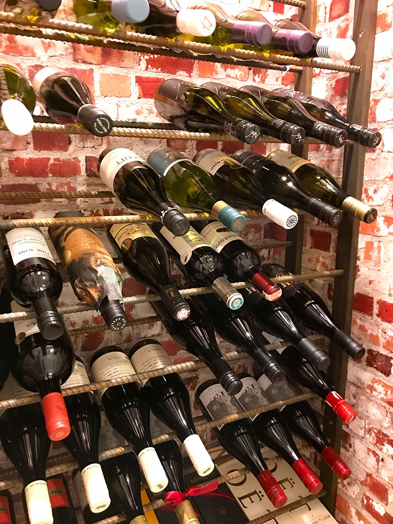 Stunning Wine cellar with bricked paper walls, and iron rods for shelving in award winning home