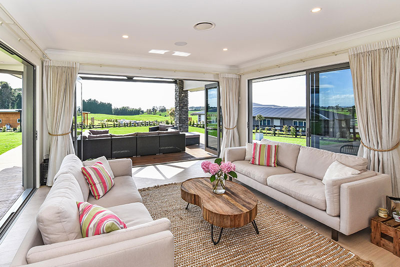 large open family area with timber floor and opening up to expansive decking on each side