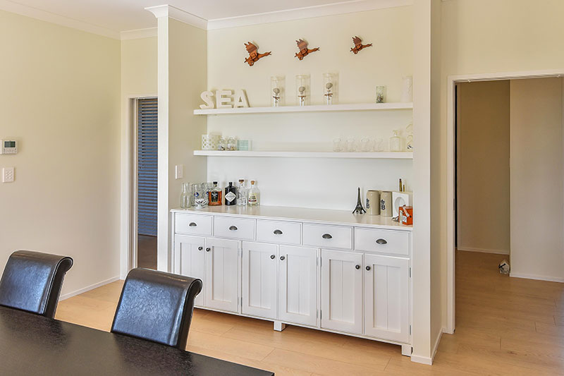 Custom built in dining cabinet and floating shelves, drinks / bar area. Wooden flooring