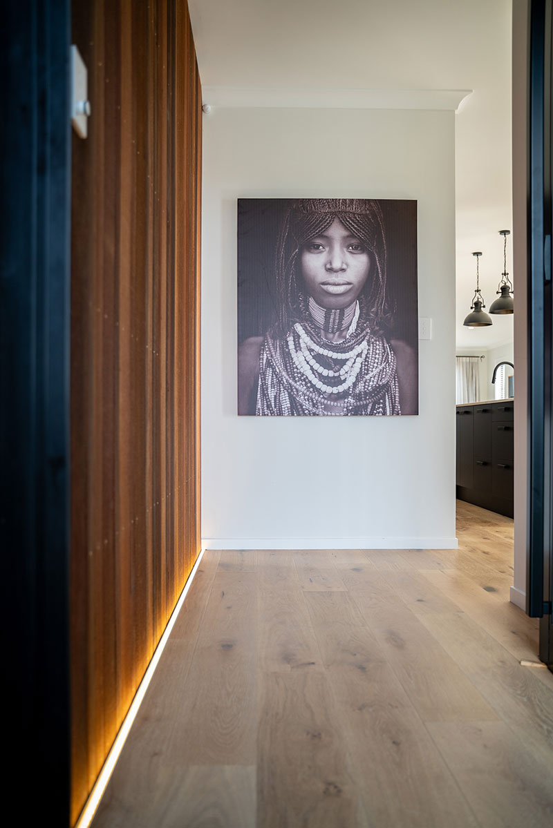 Beautiful Entranceway with cedar panelled interior wall with LED strip lighting & black and white art