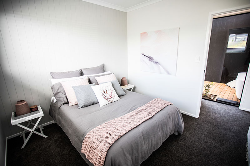 grey and blush bedroom with outdoor bath seen through window