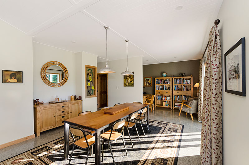 Dining and study nook with timber accents, stanined glass panel and concrete floor