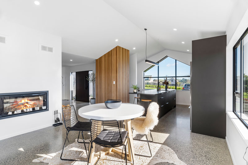 beauitful open plan kicthen dining and living room with fireplace and timber clad feature wall