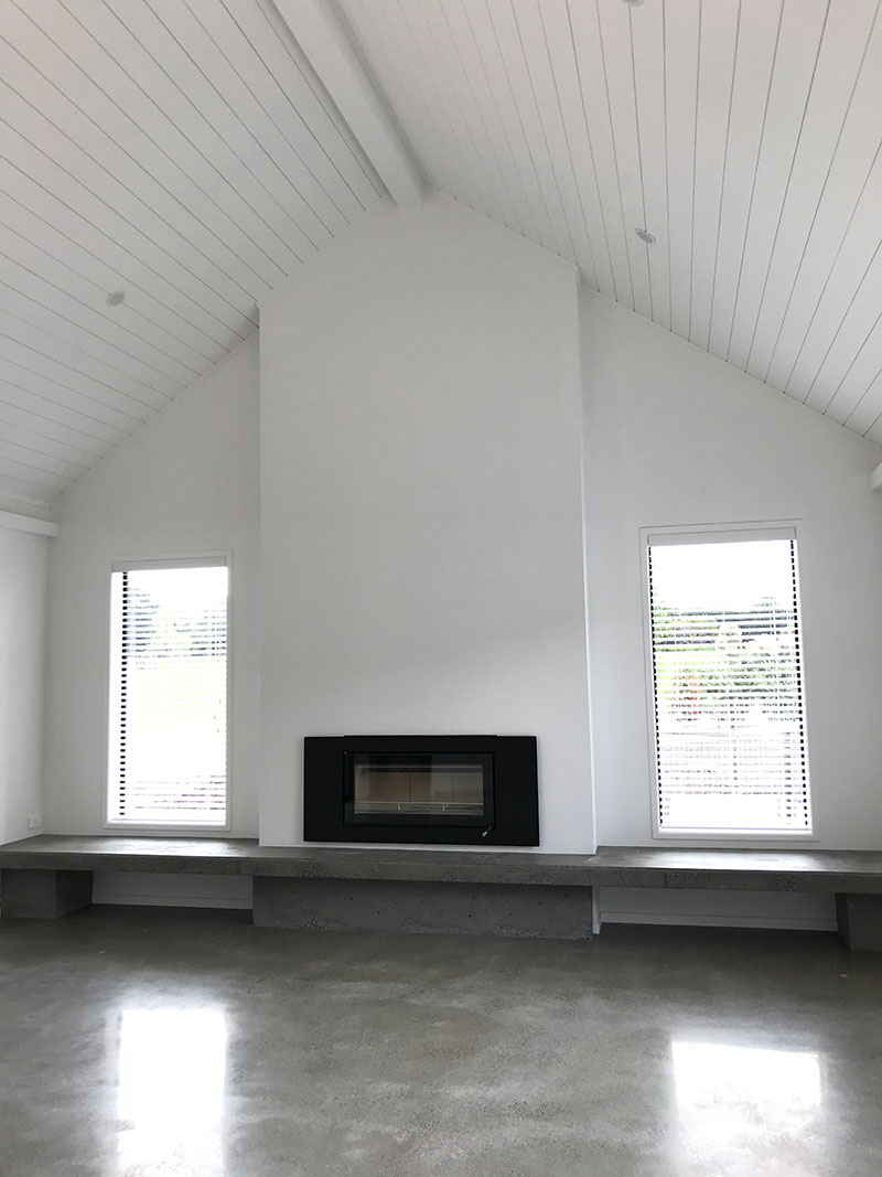 high stud sarked raking ceilings in hardigroove with fireplace with concrete hearth and polished concrete floor