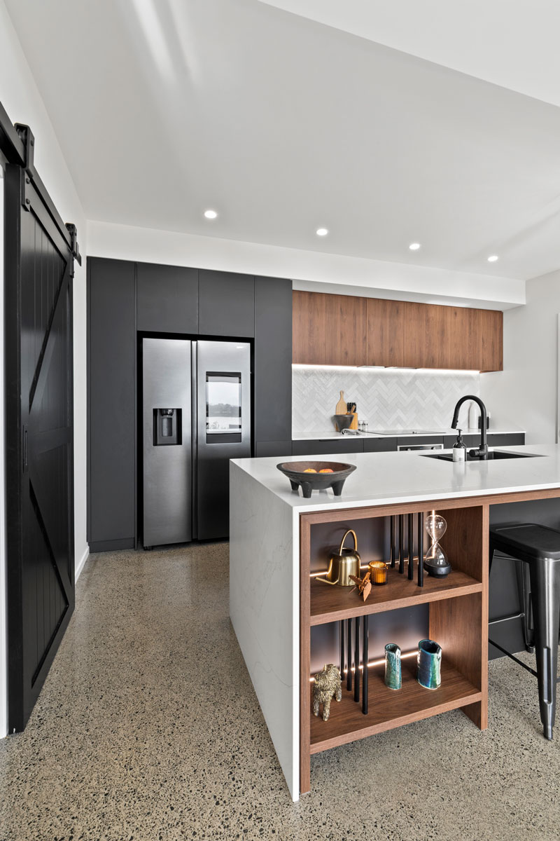 Gorgeous kitchen with black cabintry marble benchtop, and timber accents in designer home in Glenbrook