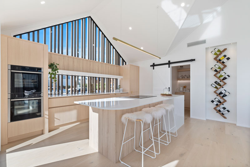 Gorgeous light timber scandinavian kitchen with brass fittings, barn door, wine rack, Paerata Rise showhome