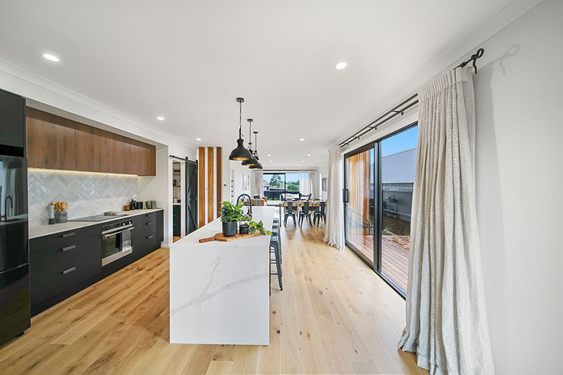 Statuario Venato Leather marble benchtop with black and Tahoe walnut cabinets and herringbone splashback