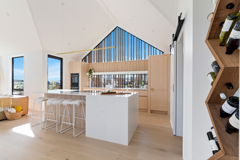 Gorgeous light timber scandinavian kitchen with brass fittings, barn door, wine rack, Paerata Rise showhome