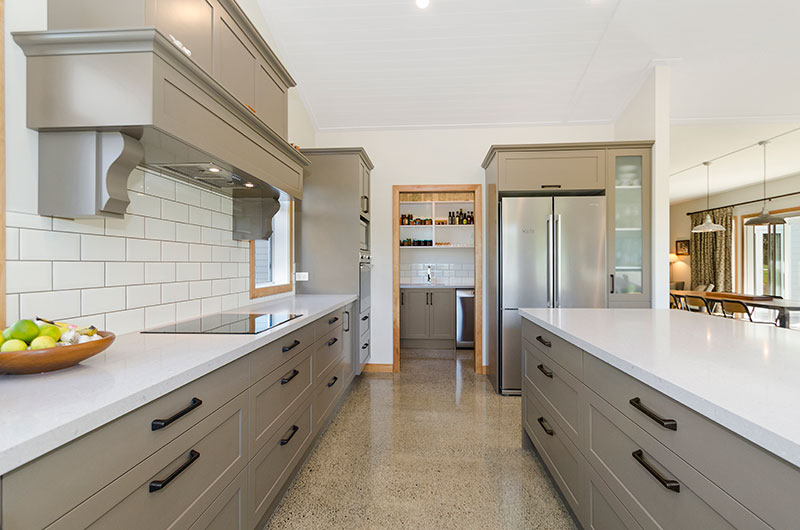 Beautiful colonial, traditional style kitchen with olive green cabinets, white benchtop and concrete floor