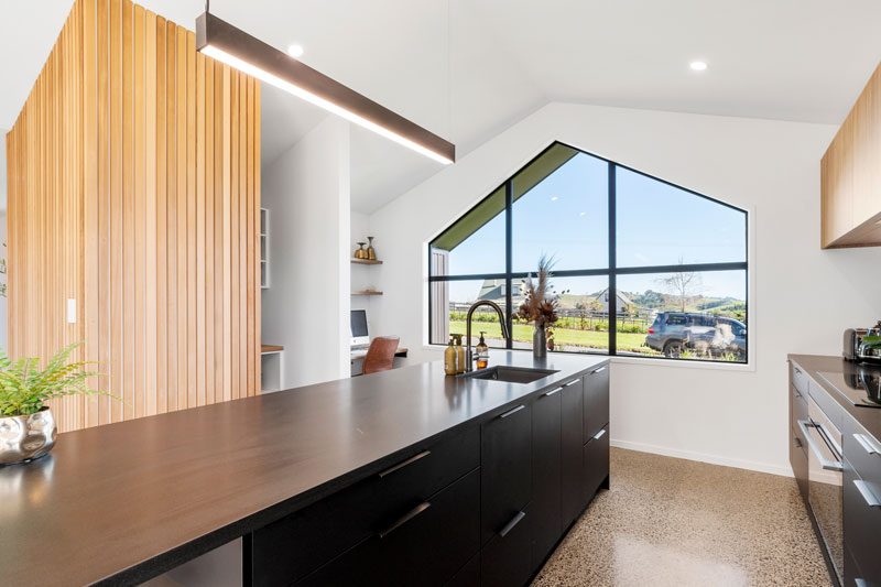 Gorgeous timber feature wall in black kitchen and large peaked window in award winning Franklin home