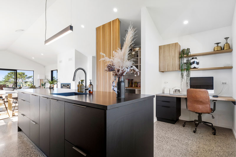 Gorgeous study nook off kitchen. with timber accents and polished concrete floors. Black kitchen