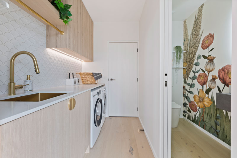 stunning timber brass and white laundry and guest toilet with feature wall in Paerata Rise showhome